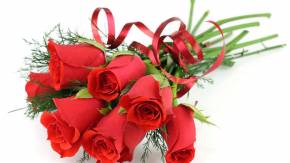 Украшенные красные розы на белом столе на  8 марта